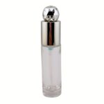 A 1 oz clear glass cylinder treatment bottle featuring a high-precision white pump and a premium transparent diamond-cut overcap. The bottle is shown in a professional studio setting, highlighting the multi-faceted, light-catching properties of the cap.