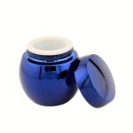 A 1.69 oz (50 g) clear glass jar with a perfect spherical shape and a heavy glass base. The jar is topped with a minimalist silver domed cap, reflecting a modern and sculptural luxury aesthetic.