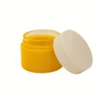 A yellow 50g straight-sided glass jar with a black smooth screw-top lid.