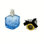 A 50ml clear blue tone square glass perfume bottle with a transparent top and a black satin bow tied around the neck.